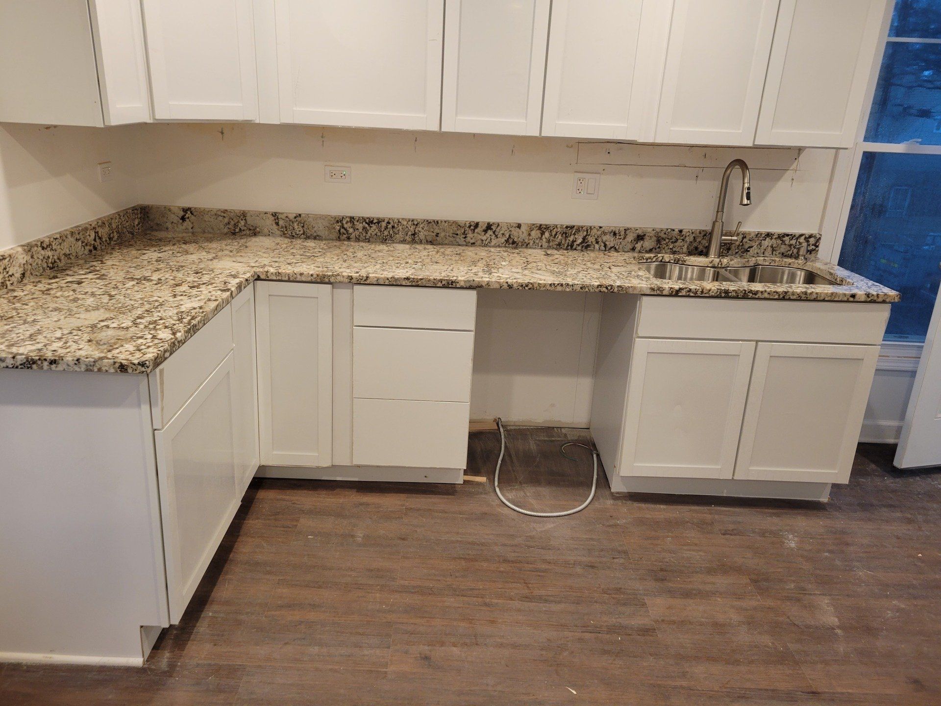 Granite countertop next to sink in unfinished apartment