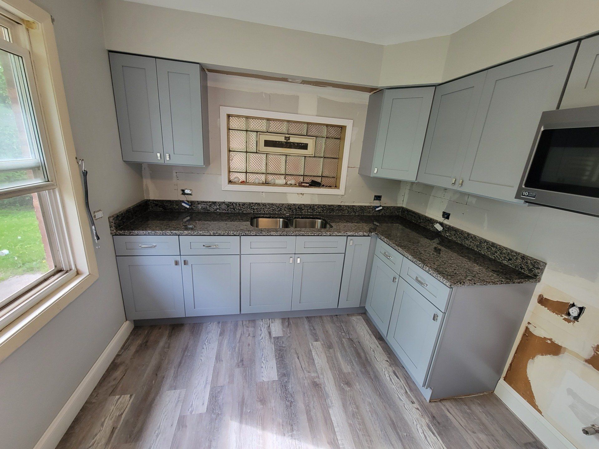 Granite kitchen countertop next to gray cabinets in a Chicago apartment